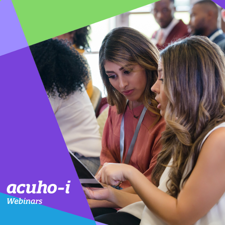 Two women sitting together in an audience look at a tablet, discussing something. Other people are seated nearby. The bottom left corner features a colorful graphic with the text acuho-i Webinars.