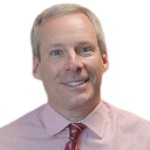 Smiling man with short gray hair, wearing a light pink collared shirt and a red patterned tie, against a plain white background.
